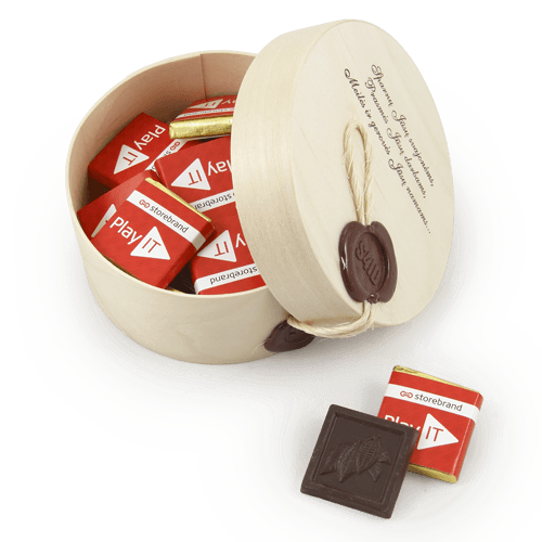 Reklaminiai šokoladukai apvalioje medinėje dėžutėje su logotipu. Rudos 
spalvos logotipas arba užrašas ant dangtelio. Įspaudas ant dekoratyvios smalkos štampo. Lininė virvelė.