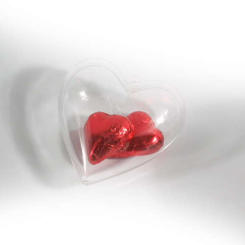 Stilizuota širdelės formos dėžutė iš skaidraus plastiko su kilpute pakabinimui arba kaspinui. Dėžutė iš dviejų susirakinamų dalių. Tinka smulkiam suvenyrui arba saldainiams supakuoti arba kaip dekoracija. 
 