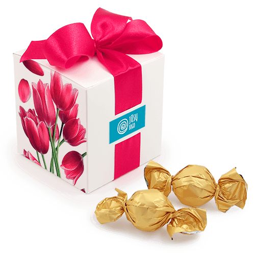 Visų švenčių sezonų bestseleris! Elegantiška kubelio formos saldainių dėžutė gali tapti Jūsų įmonės vizitine kortele. Nepriekaištingas verslo dovanos pasirinkimas – balta dėžutė su logotipu, perrišta derančios spalvos juostele. 